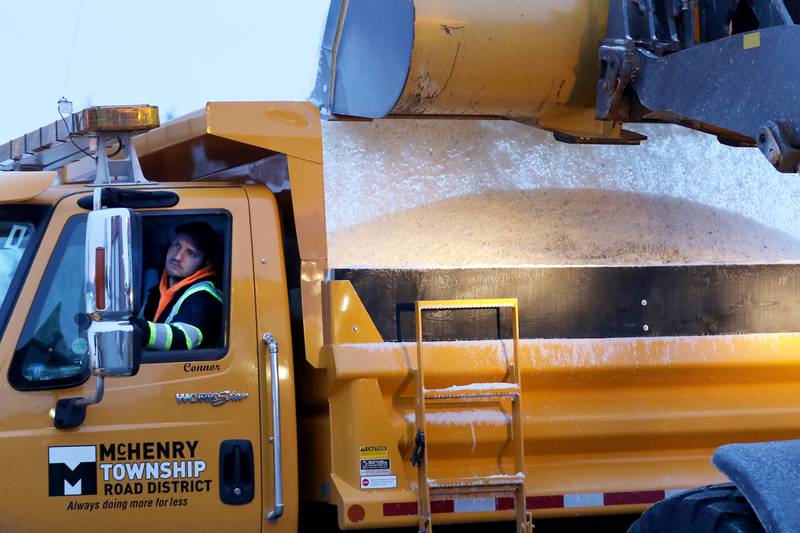 Road crew members load their vehicles with a salt mixture a little after 7 a.m. at the McHenry Township Road District in Johnsburg in this February 2021 file photo.