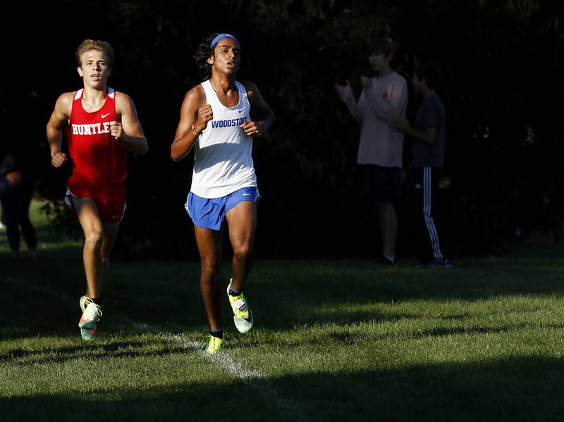 Huntley’s Tommy Nitz, chases Woodstock’s Ishan Patel, during the boys race of the McHenry County Cross Country Meet Saturday, August 27, 2022, at Emricson Park in Woodstock.