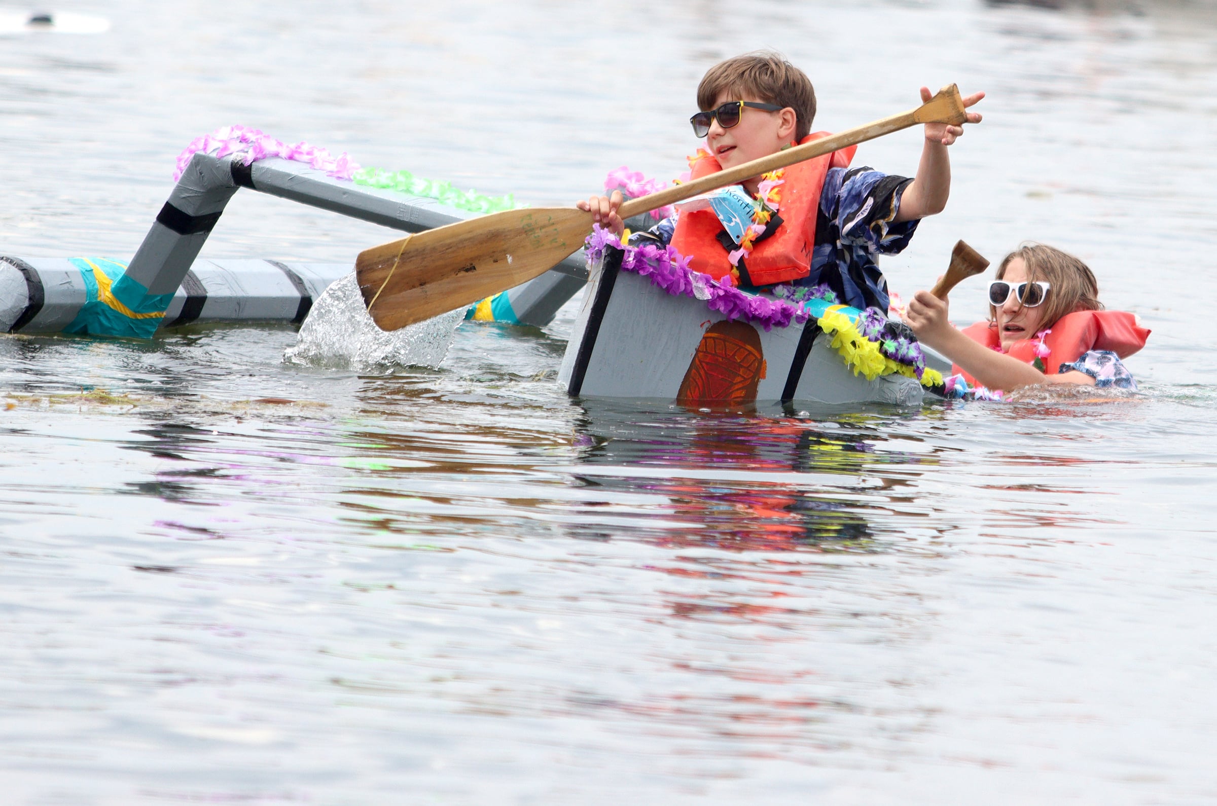 Wouter Dahlquist, 12, front, and his twin brother Thijs of Crystal Lake try to right their ship during the Cardboard Regatta on Crystal Lake Saturday.