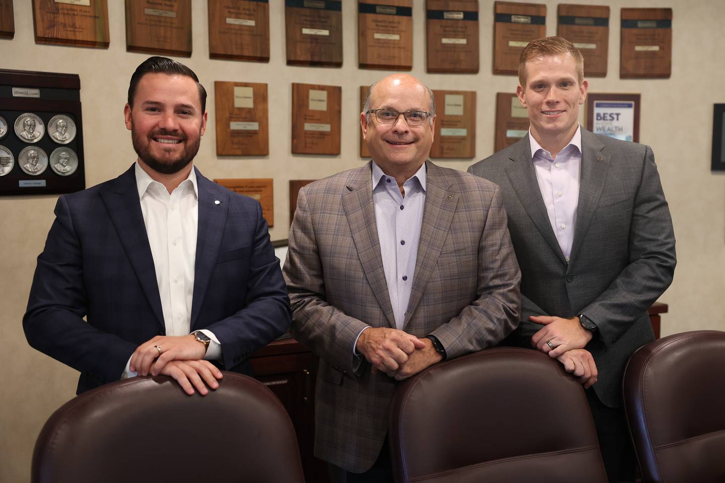 Edward Dollinger, center stands with his son, Matthew Dollinger, right, and son-in-law Scott Segobaino, left, at his Edward Jones business in Joliet.