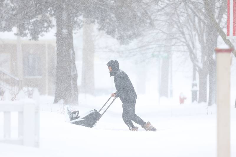 Daniel Hernandez snow blows his driveway along North Raynor Avenue. Wednesday, Feb. 2, 2022, in Joliet.
