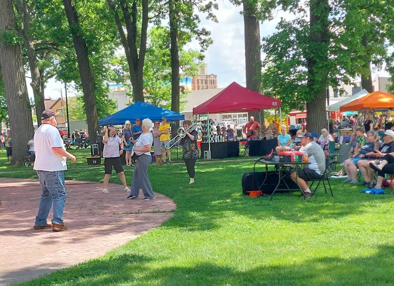 A trombone player from Riker Maneuver makes her way to some dancers at City Park on Saturday, May 18, 2024, as the band performed during the Food Truck Festival.