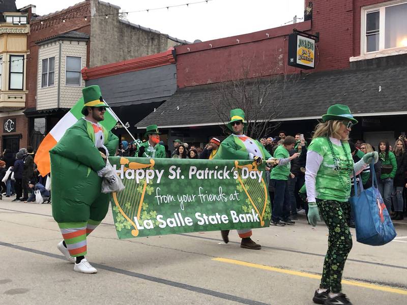 Participants in the St. Patrick's Day parade march down the street on Saturday, March 11 in downtown Utica.