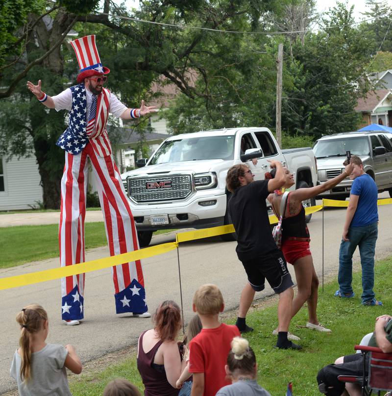 Shaneka Meyer of Rockford and Zach Noone of Freeport take a selfie with Stiltwalker Jason Kollom during the German Valley Days parade on Saturday, July 20, 2024.