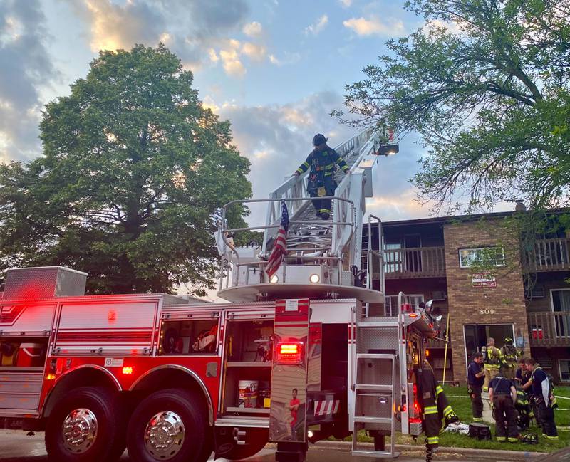 A DeKalb fire engine deploys a ladder truck as a firefighter descends from the roof where the worst of the smoke swelled as crews responded to a structure fire at a Husky Ridge apartment complex in the 800 block of Kimberly Drive, DeKalb, on Wednesday evening, May 29, 2024.
