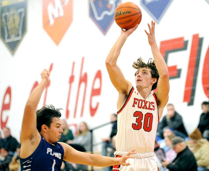 Yorkville's Bryce Salek (30) shoots and drains a three-pointer against Plano defender Armando Martinez (1) during a varsity basketball game at Yorkville High School on Tuesday, Dec. 19, 2023.