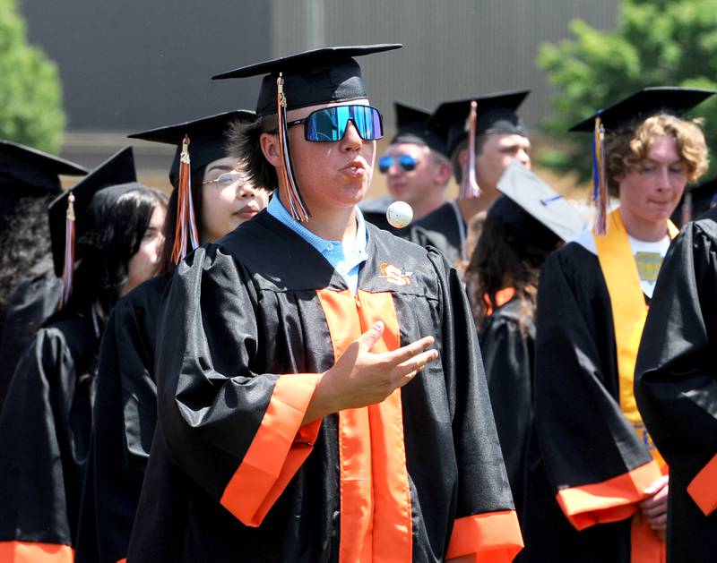 Christopher Barbor juggles a golf ball during Pomp and Circumstance at Sandwich High School's graduation ceremony on the football field, Sunday, May 19, 2024.