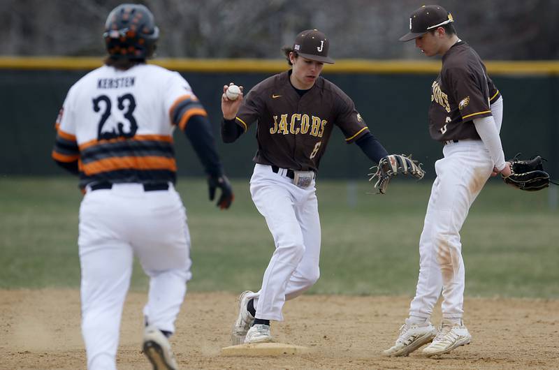 Jacobs's Caden Guenther steps on second base to force out McHenry’s Cole Kersten as his teammate, Drew Bennett, stays out of his path during a Fox Valley Conference baseball game Friday, April 15, 2022, between Jacobs and McHenry at Petersen Park in McHenry.6\