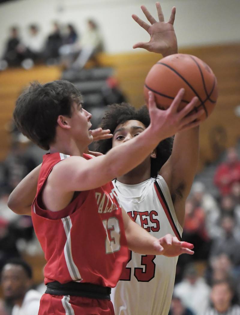 Palatine’s Carter Monroe lays up a shot against Yorkville’s Jory Boley in a quarterfinal game of the Jack Tosh Classic at York High School in Elmhurst on Thursday, Dec. 28, 2023.
