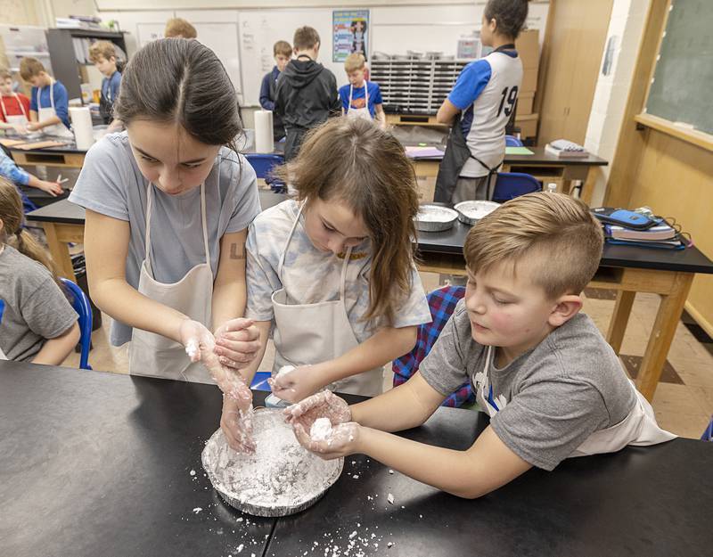 Ruth Shearer (left), 4th grade, Charlotte Baker, 3rd grade and Gradnt Woodall, 2nd grade, work on making a snowman out of shaving cream and baking soda Thursday, Feb. 1, 2024 at St. Mary’s School in Dixon. Local professionals were brought in for fun and education with the students in celebration of Catholic Schools Week.