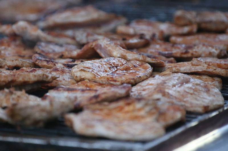 Boneless pork chops cook on the grill outside Richard Nesti Stadium on Friday, Sept. 8, 2023 in Spring Valley.. In 2022, the IHSA and the Illinois Pork Producers awarded Hall as having the best concession stand port chop sandwich in the state