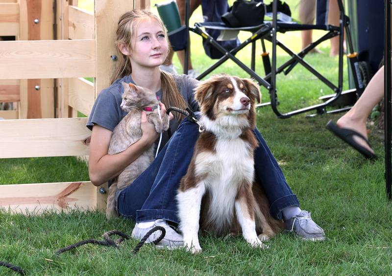 Libby Johnson, 16, from Shabbona, takes a break with her dog Earl and cat Gray at the Indian Creek Future Farmers of America booth Saturday, July 15, 2023, at the Waterman Lions Summerfest and Antique Tractor and Truck Show at Waterman Lions Club Park.