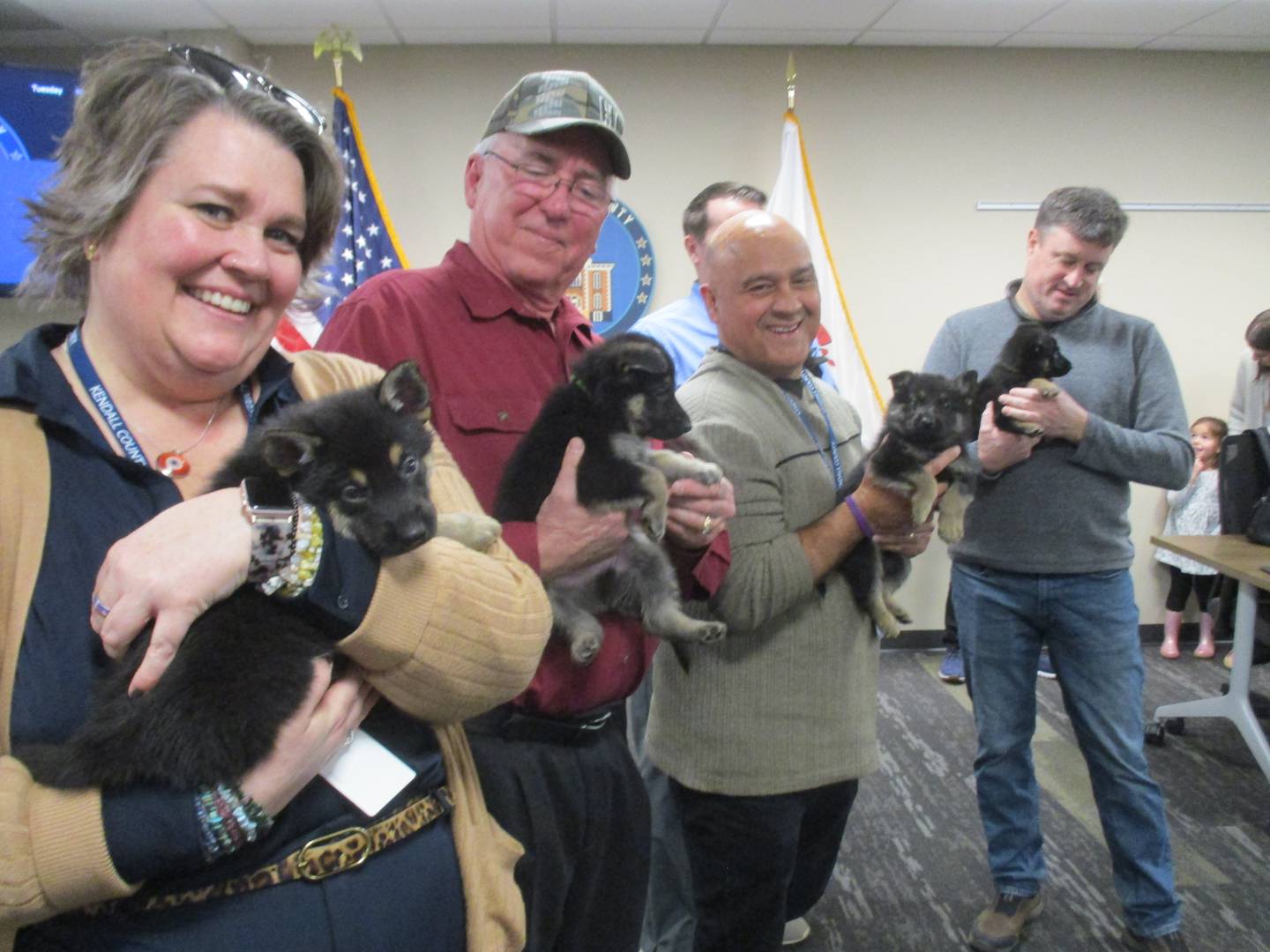 Kendall County Board members cuddle German Shepherd puppies that are available for adaption from Kendall County Animal Control, at the March 7, 2023 meeting. They are, from left, Brooke Shanley, Brian DeBolt, Ruben Rodriguez and Chairman Matt Kellogg.