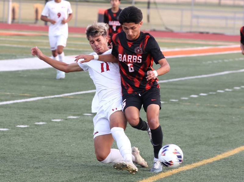 DeKalb's Mauricio Jasso (right) tries to avoid the slide tackle of Rockford East's Jovanni Ortega Cardenas during their game Thursday, Sept. 12, 2024, at DeKalb High School.