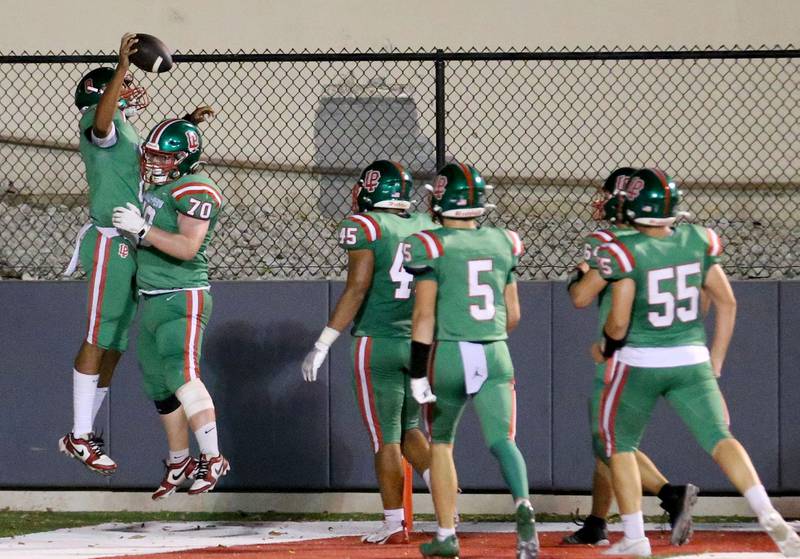 L-P quarterback Marion Perish celebrates scoring the teams first touchdown with teammate Evan Haskell and others against Ottawa on Friday, Sept. 13, 2024 at Howard Fellows Stadium.