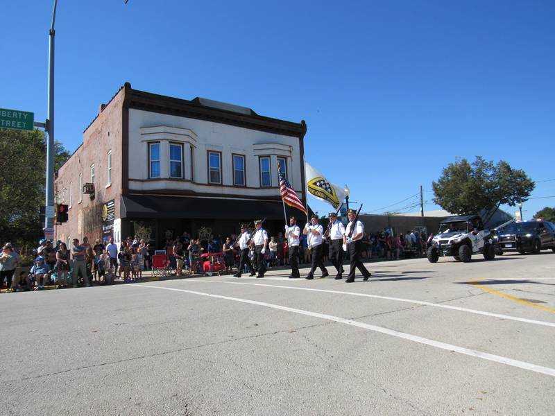 Dr. Larry Johnson (right) marches with the Morris Color Guard during the Corn Festival parade.