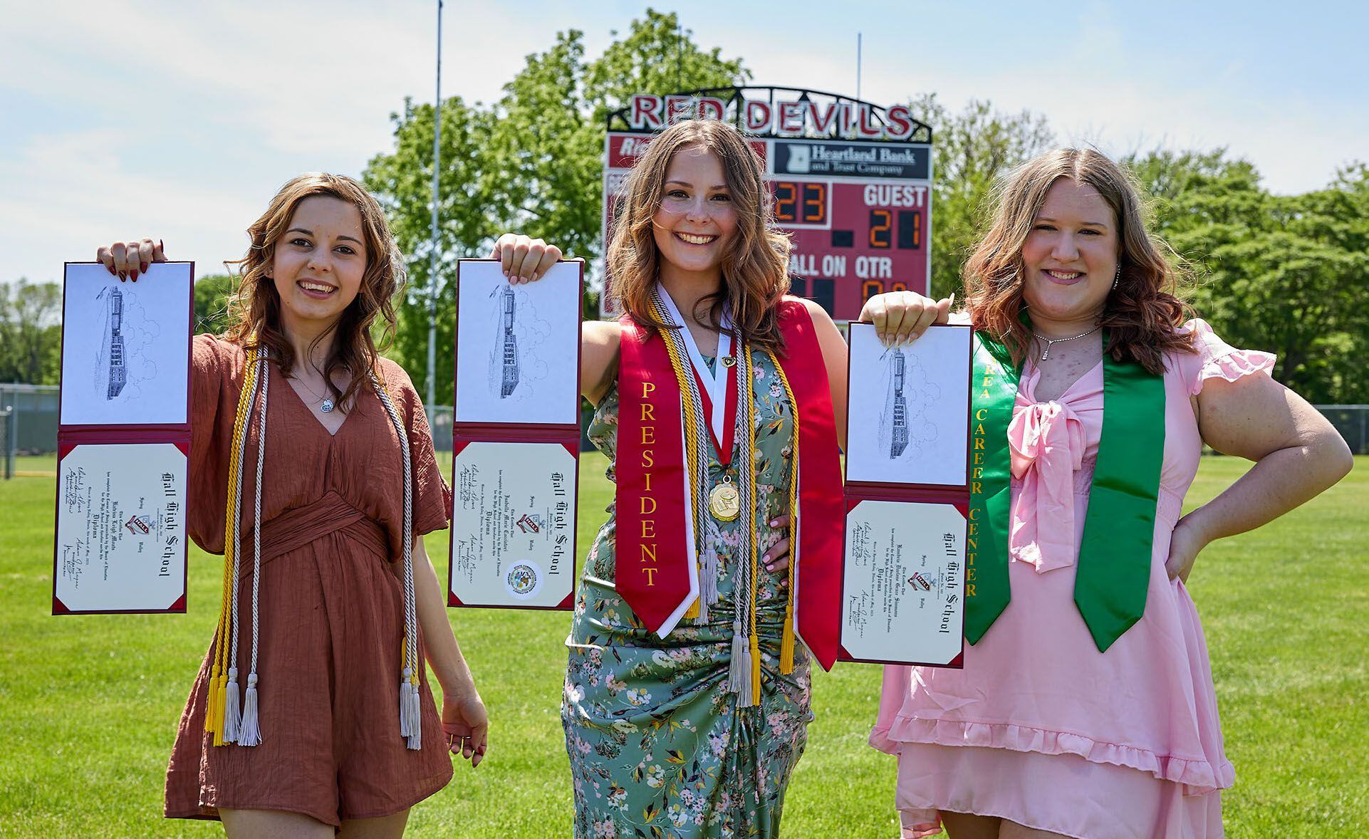 Hall High School graduates Katrina Moats, Izzie Cacciatori and Kambria Simmons hold their diplomas during the graduation ceremony on Sunday, May 21, 2023, at Hall High School.