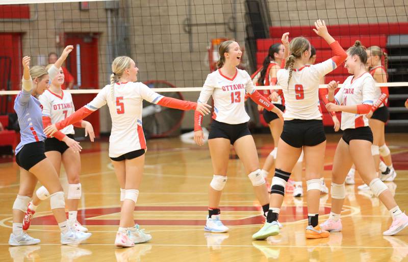 Members of the Ottawa volleyball team react after scoring a point against Streator on Thursday, Aug. 29, 2024 in Kingman Gym at Ottawa High School.