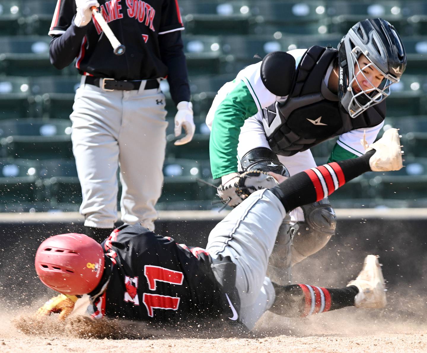 York catcher Owen Chael tags out Maine South’s Chris Gonzalo, who was attempting to steal home to win the game with the score at 8-8 in the bottom of the seventh inning at Wintrust Field on Wednesday, March 27, 2024 in Schaumburg.