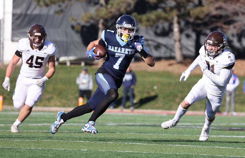 Nazareth's Jake Cestone splits two Joliet Catholic defenders on his way to the endzone after a catch Saturday, Nov. 25, 2023, during their IHSA Class 5A state championship game in Hancock Stadium at Illinois State University in Normal.