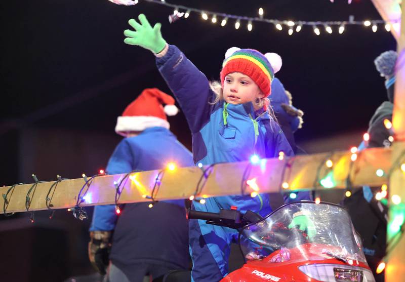 A parade participant throws candy to onlookers Friday, Dec. 2, 2022, during Celebrate the Season hosted by the Genoa Area Chamber of Commerce.