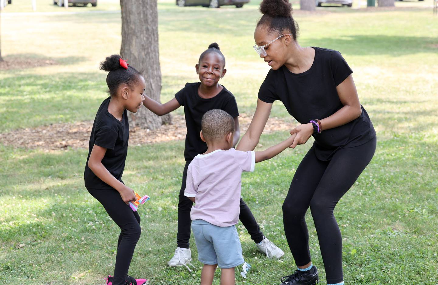 Kennedy Wilkins, (clockwise from left) 7, Kacee Wilkins, 10, Zoey Hollins, 12, and RJ Wilkins, 2, from Cortland, dance to the music played by the DJ at the Juneteenth Community Celebration Sunday, June 18, 2023, at Hopkins Park in DeKalb. The event featured vendors, food, music, games, and more.