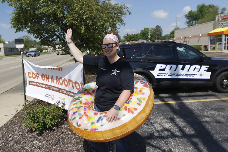 McHenry Police Public Information Officer Ashley O'Herron waves to motorists during the Cop on a Rooftop fundraiser for Special Olympics Illinois on Friday, May 17, 2024, at the Dunkin Donuts at 4502 Elm Street in McHenry. Law enforcement officers spent their morning raising funds and awareness for Special Olympics Illinois and the Law Enforcement Torch Run.