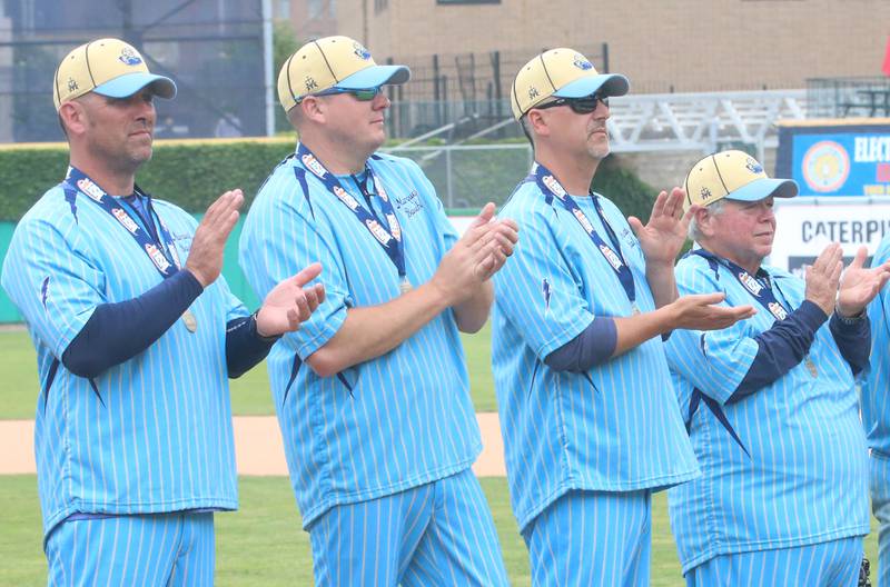 Marquette coaches Brad Waldron, Brian Bressner, Matt Nelson and manager Steve "Pizza" Scherer applaud as the team receives its medals after defeating Atlamont to win the Class 1A State championship title on Saturday, June 1, 2024 at Dozer Park in Peoria.