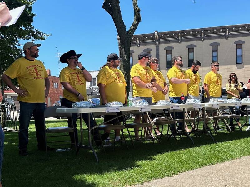 Contestants line up and prepare to eat way too many hot dogs during the 2024 Grundy Bank Hot Dog Eating Contest.