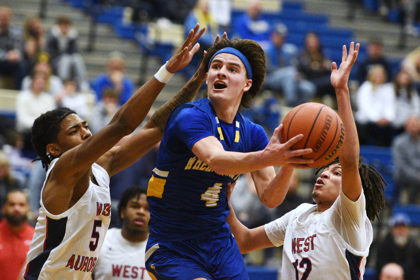 Wheaton North's Hudson Parker (4) heads to the hoop past West Aurora's Terrence Smith (5) and Mike Evans during the boys basketball game on Monday, Jan. 15, 2024 in Geneva.