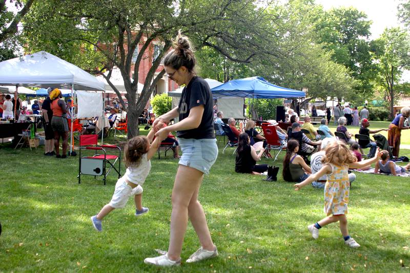 Sasha Gomez of Chicago dances to live music with her two daughters during McHenry County’s 2nd Annual Juneteenth Festival at the Woodstock Square Saturday.