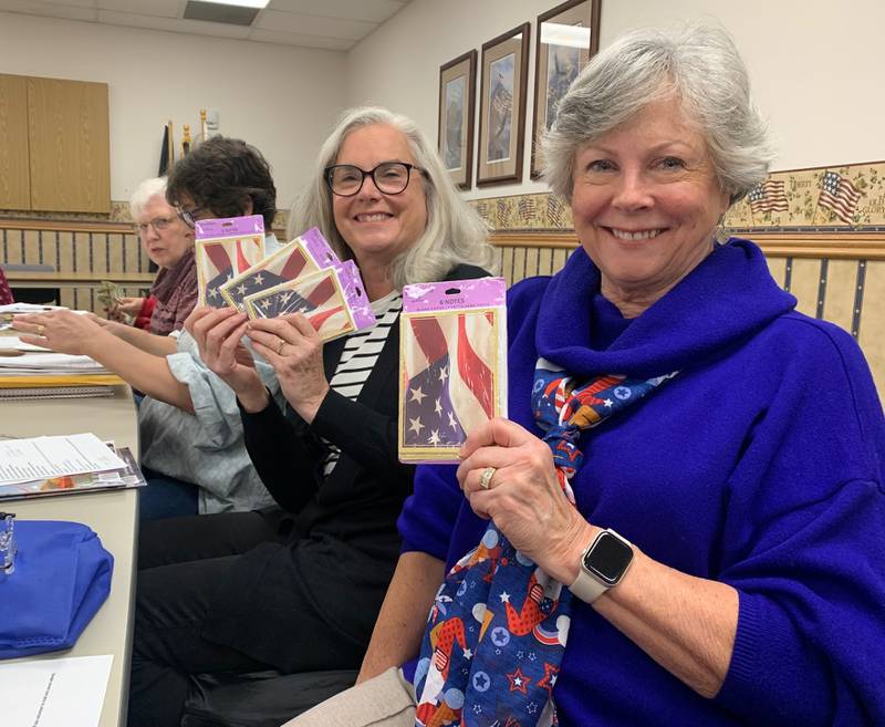 Fort du Rocher Chapter of the Daughters of the American Revolution Laura Schaefer and Ruth Meinhardt divide up cards for Honor Flight veterans.