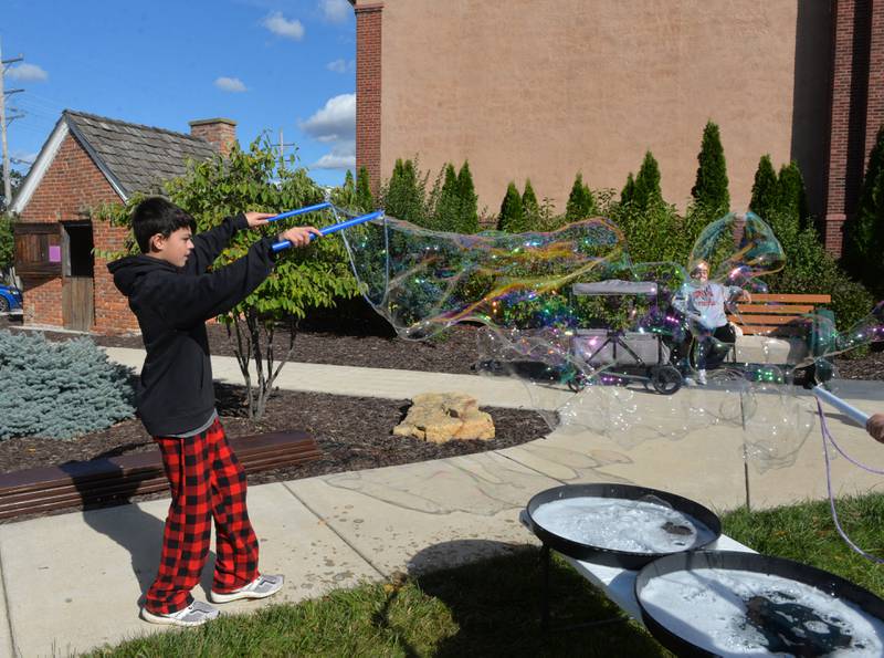 Braydyn Mireles, 13, of Belvidere, makes a big bubble at Autumn on Parade on Saturday, Oct. 7, 2023. The bubble show, created by Jason Kollom, was one of the free activities for kids in the Fun Zone.