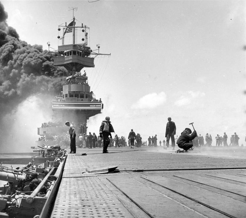 A scene on board the USS Yorktown (CV 5) during the Battle of Midway, shortly after three Japanese 
bombs hit the ship on June 4, 1942. The dense smoke is from fires in the uptakes, which was caused by a 
bomb that punctured them and knocked out the ship’s boilers