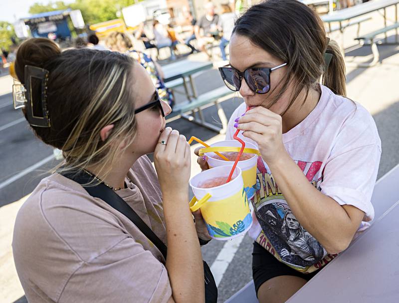 Lexy Schoaf (left) of Rock Falls and Caitlin Farley of Dixon dig into a couple rum buckets Saturday, Sept. 2, 2023 Dement Town Music Fest in Dixon. Sponsored Discover Dixon, the inaugural west end festival feature three musical acts, food and drink