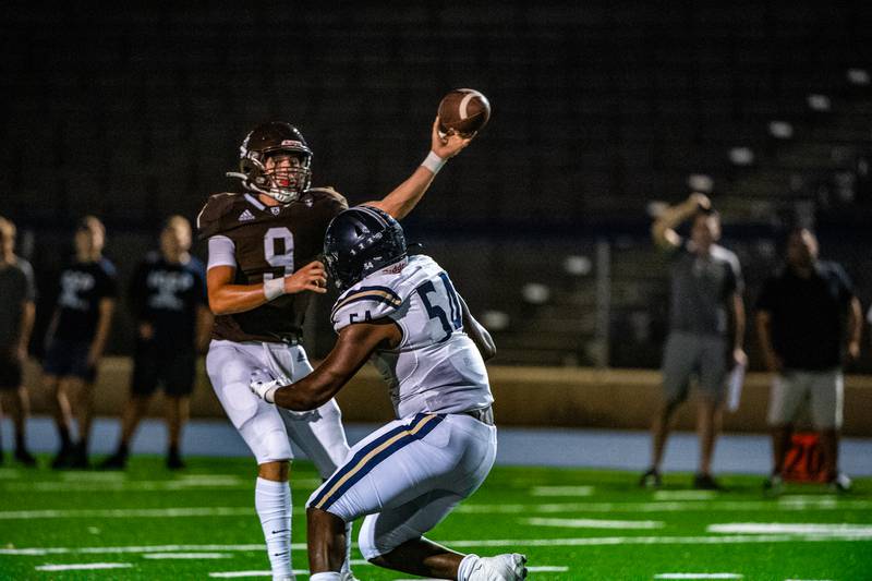 Joliet Catholic's TJ Schlageter throws a pass while being pressured by Immaculate Conception's Jayden Sutton during a game Friday, Sept. 2, 2022, at Memorial Stadium in Joliet.