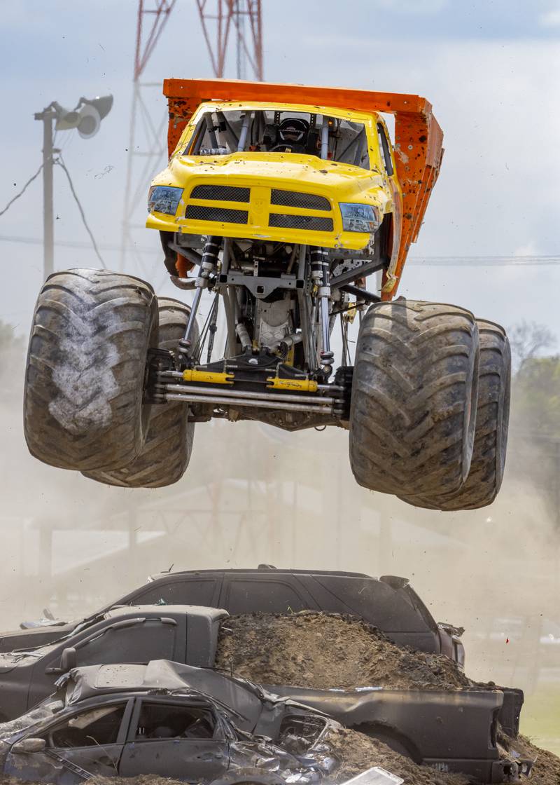 The Dirt Crew truck leaps over smashed cars Saturday, July 202, 2024, during the Overdrive Monster Truck Show at Bureau County Fairgrounds in Princeton.