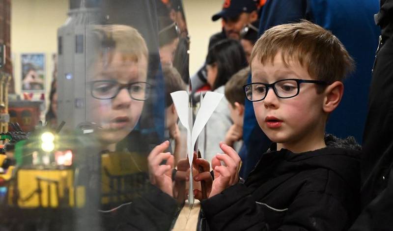 Andrew Kramer, 6, of West Dundee, peers through the Plexiglas to see a train rumbling down the tracks Sunday, April 2, 2023, during the Northern Illinois Lego Train Club's expo at the Fox River Valley Public Library in East Dundee.