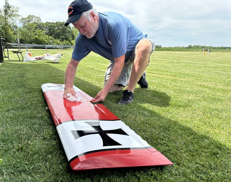 Bill Alleman of Tonica, wipes grease off of wings from his model airplane on Monday, July 1, 2024 at the Model Airplane Field inside Matthiessen State Park in Oglesby.