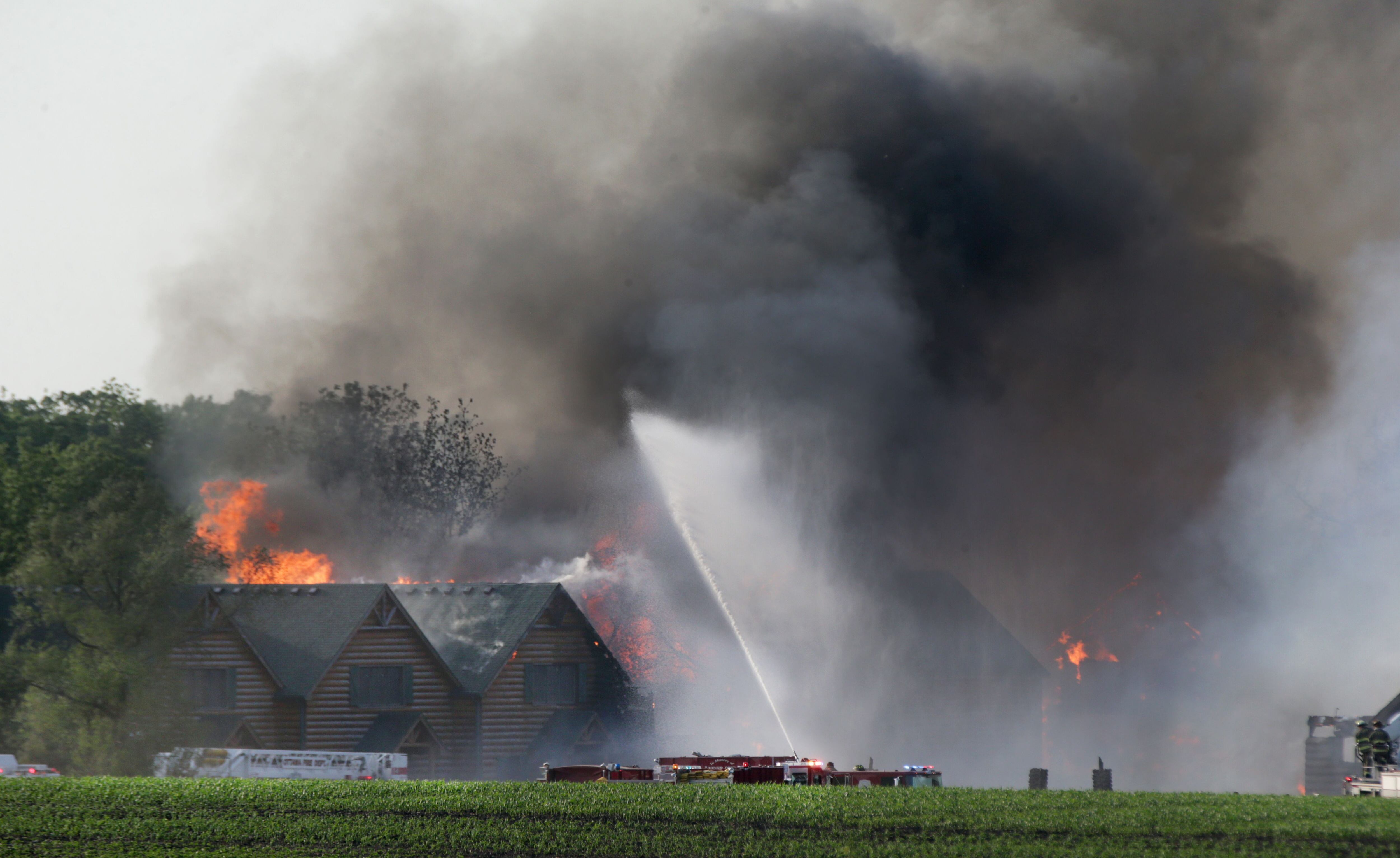 Flames emit from several cabins at Grand Bear Resort as firefighters work to extinguish the blaze. Strong winds pushed the flames to neighboring cabins.