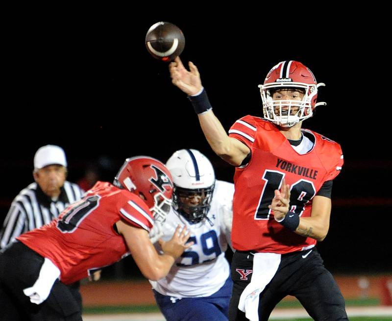 Yorkville quarterback Jack Beetham (18) avoids the Plainfield South rush to throw a pass on Friday, Sep. 30, 2024, at Yorkville High School.