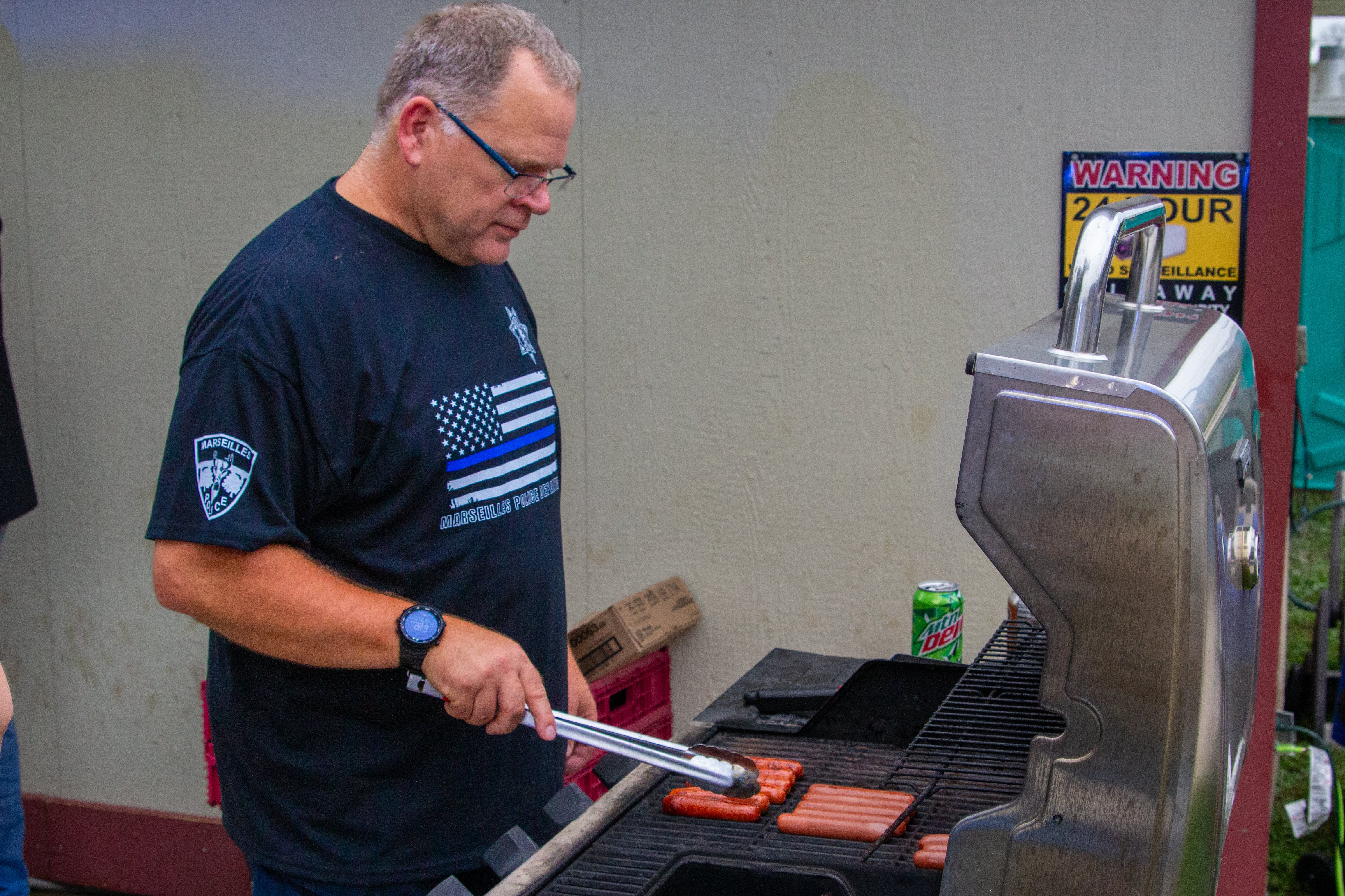 Dan Ellis makes hot dogs on Tuesday, August 6, 2024 at Marseilles Swimming Pool.