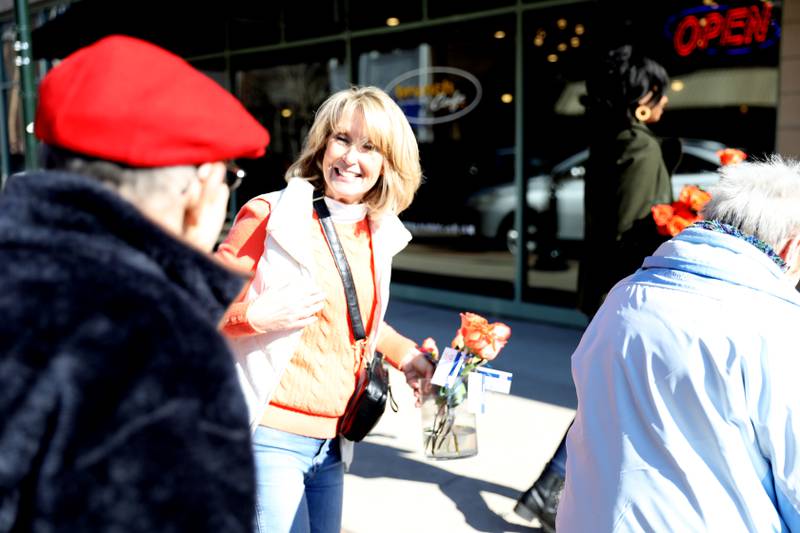 Random Acts Matter volunteer Sharon LeGare (left) hands out orange roses in St. Charles as part of Random Acts of Kindness Week on Wednesday, Feb. 14, 2024.