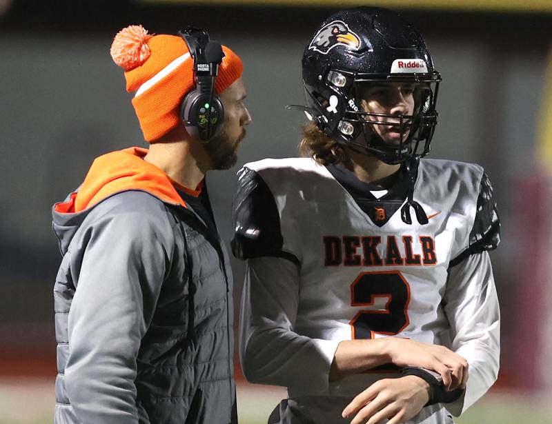 DeKalb's Cole Latimer talks to head coach Derek Schneeman during their game Friday, Oct. 6, 2023, at Naperville Central High School.