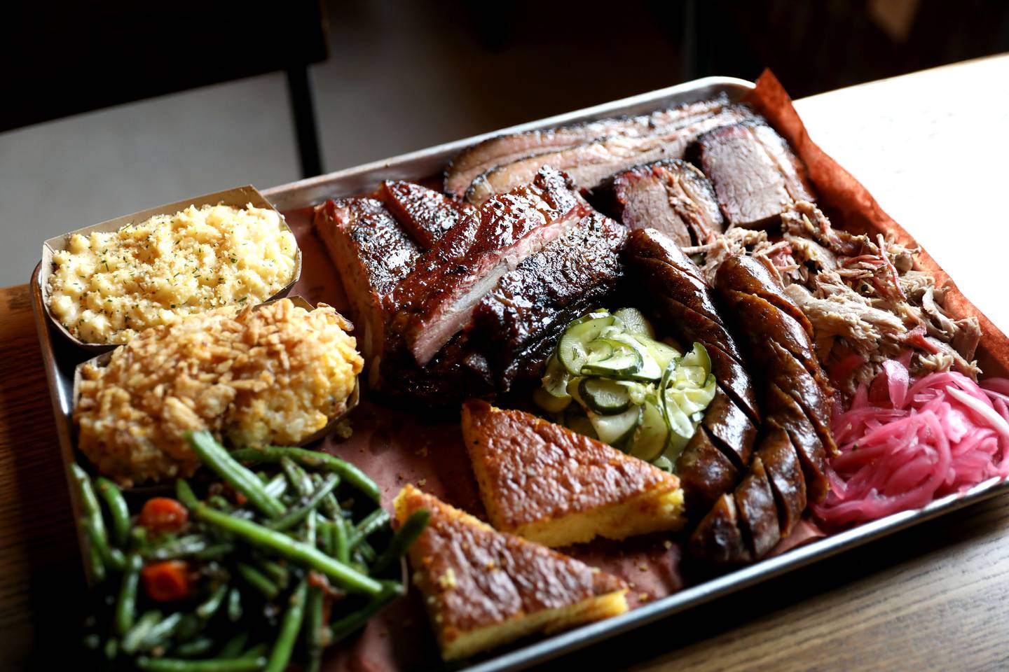 Hot links, pickled onions, house-made spicy pickles, brisket, pulled park, corn bread, pork spare ribs, green beans, tater tot casserole and macaroni and cheese at Station One Smokehouse, which recently opened at 524 E. Kendall Dr. in Yorkville.