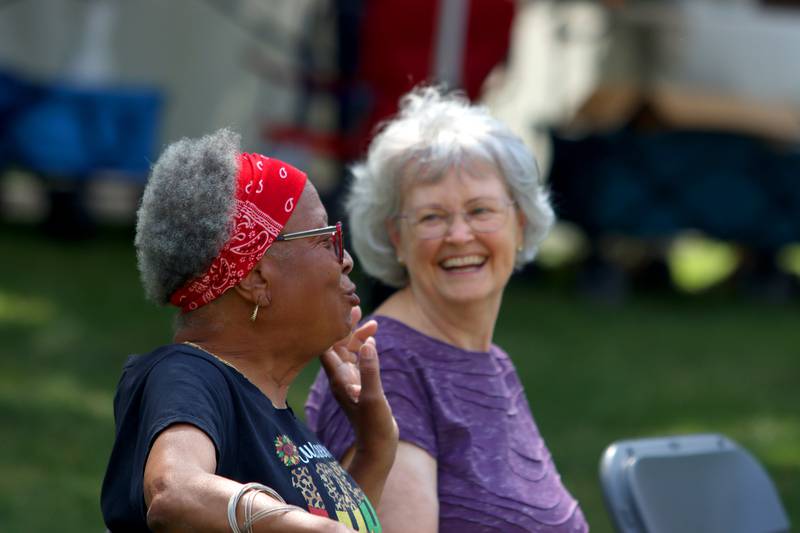 Regina Rakoncay, left, of Spring Grove shares a laugh with Sonja Brook of Huntley during McHenry County’s 2nd Annual Juneteenth Festival at the Woodstock Square Saturday.