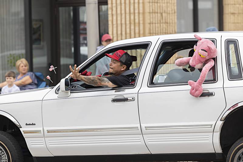 A lowrider driver throws candy from his whip Saturday, Sept. 16, 2023 during the 70th annual Fiesta Days parade as it moves through the twin cities.