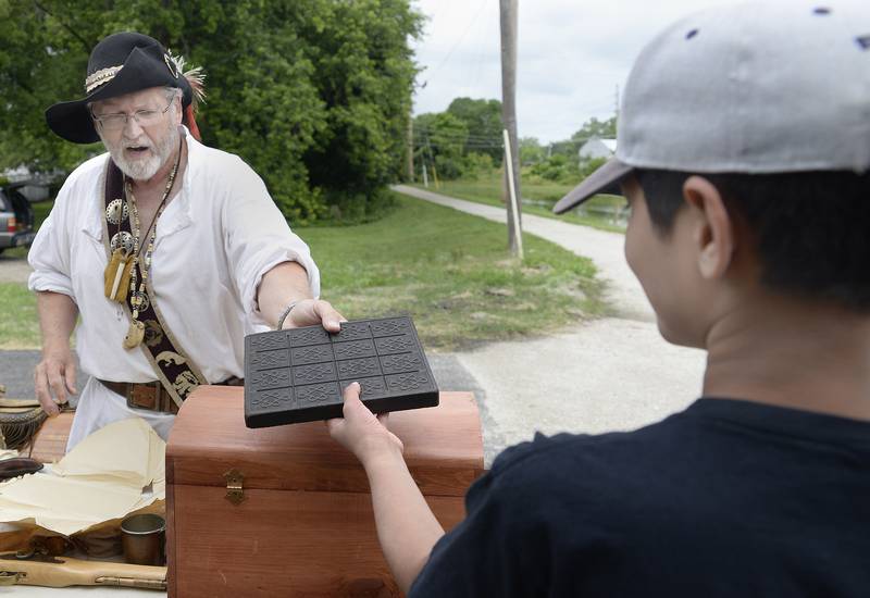 Ken Swanson as a French voyageur shows the audience a brick of tea as it looked like in the 1670s on Saturday, July 8, 2023, during Canal Day in Ottawa celebrating the 175th anniversary of the Illinois and Michigan Canal opening.