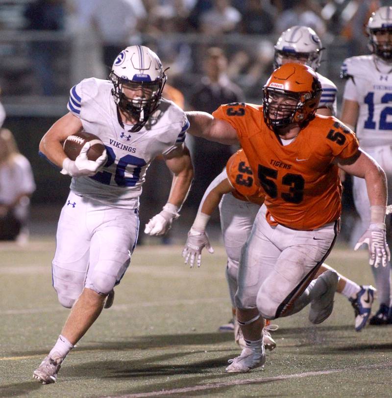 Geneva’s Michael Rumoro runs the ball as he’s chased down by Wheaton Warrenville South’s Axel Boecker during a game Friday, Sept. 13, 2024 in Wheaton.