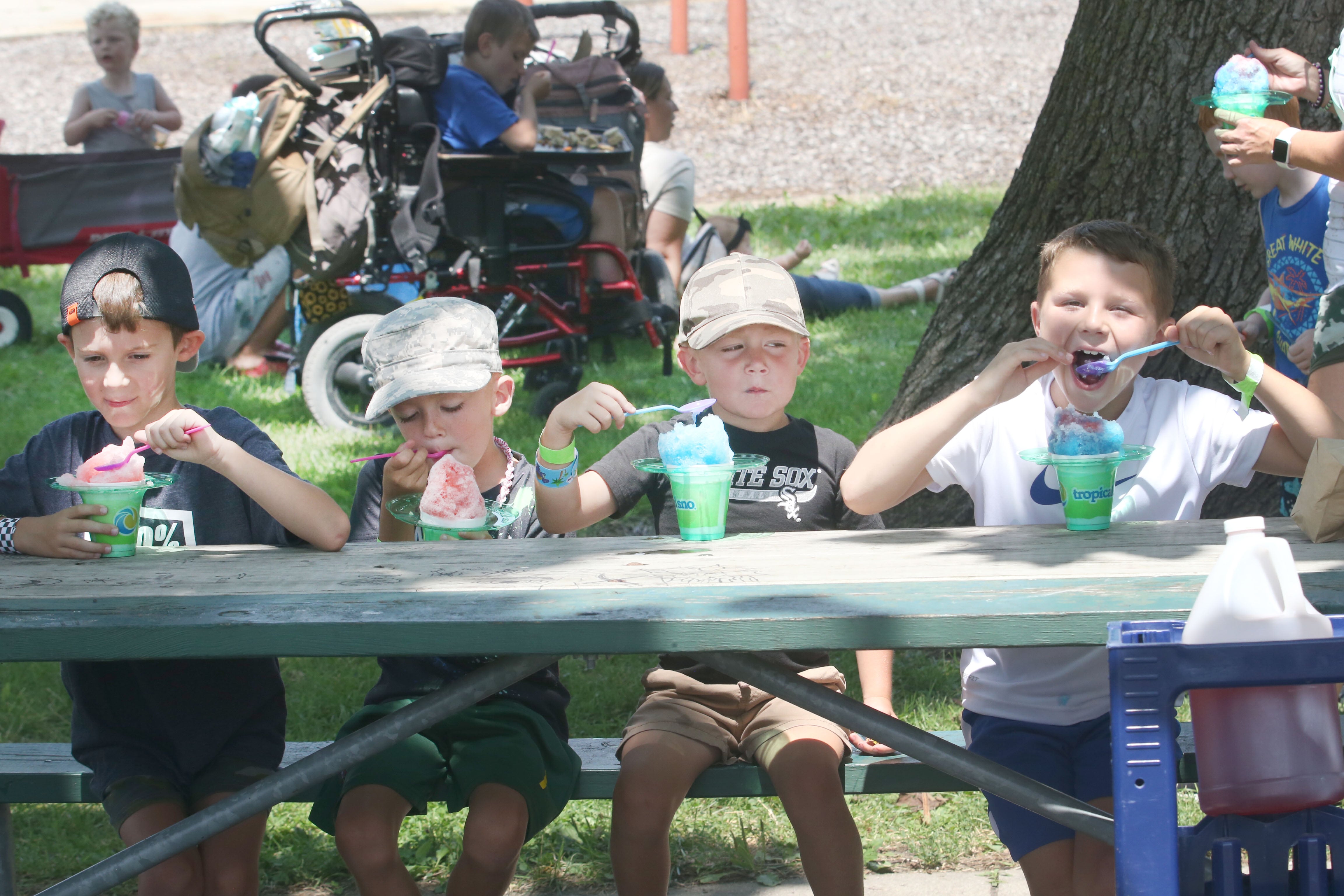 (IFrom left) Wes Rosengren, Waylon Glover, Wyatt Glover and Cassius Caupto cool off while eating snowcones during the Ottawa Recreation Summer Carnival on Wednesday, July 25, 2024 at Rigden Park in Ottawa. The carnival featured games, activities, bounce houses, and more. It wa the last event of the season.